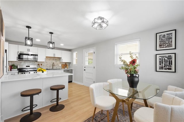 239 Merritt Ave, Carrick, PA 15227 - kitchen featuring a kitchen breakfast bar, light countertops, a sink, tasteful backsplash, and appliances with stainless steel finishes