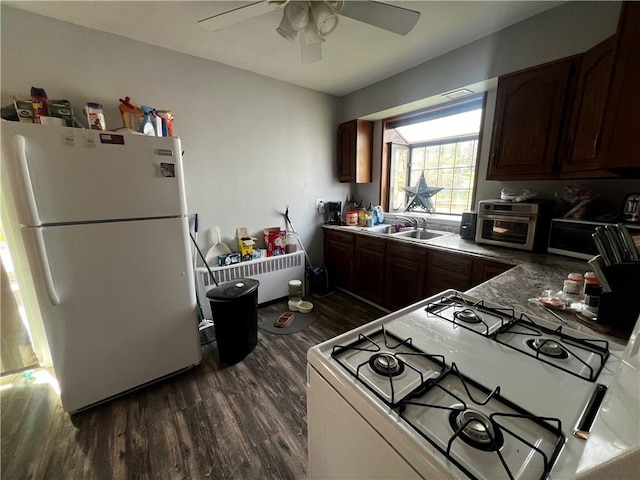 kitchen featuring dark wood finished floors, a toaster, a sink, white appliances, and ceiling fan