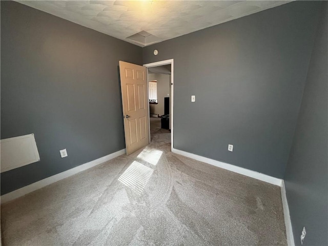 unfurnished room with baseboards and carpet