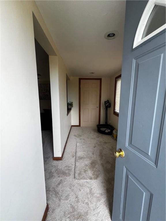 corridor with baseboards and carpet flooring
