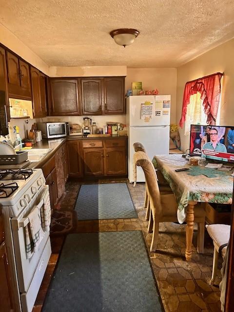 kitchen with white appliances and a textured ceiling