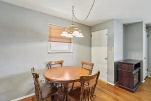 dining space featuring light wood-style flooring and an inviting chandelier