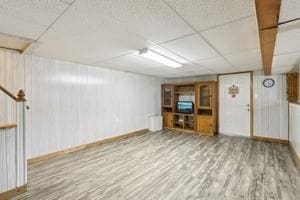 finished below grade area featuring baseboards and wood finished floors