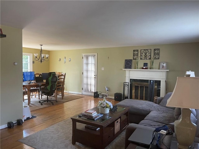 4710 Doverdell Dr, Whitehall, PA 15236 - living area with a glass covered fireplace, baseboards, wood finished floors, and a chandelier