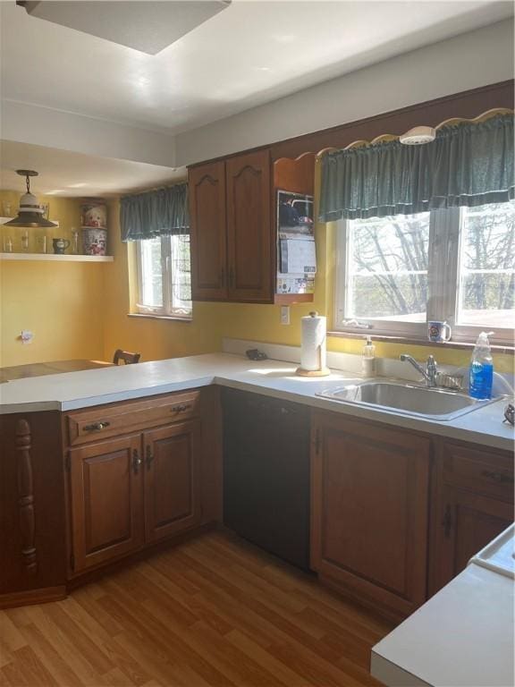 4710 Doverdell Dr, Whitehall, PA 15236 - kitchen featuring light countertops, wood finished floors, brown cabinetry, and a sink
