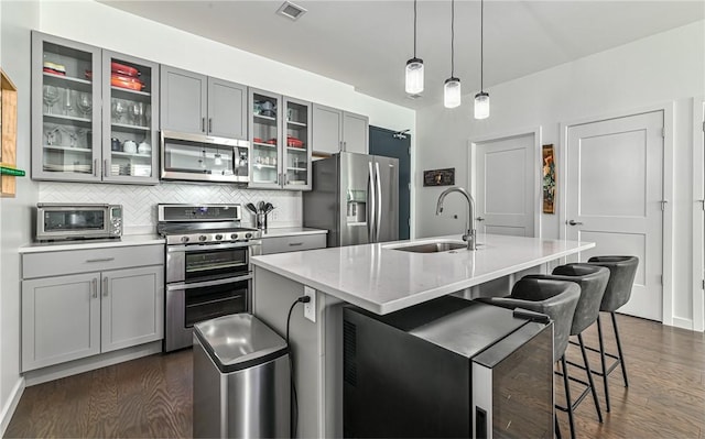kitchen featuring gray cabinetry, visible vents, stainless steel appliances, and a sink