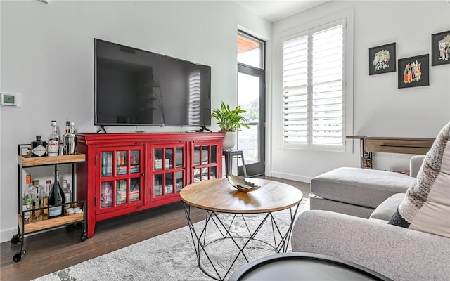 living area with baseboards and wood finished floors