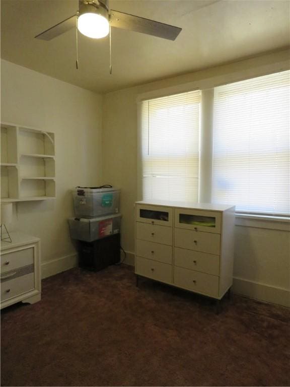 bedroom featuring a ceiling fan, baseboards, and dark colored carpet