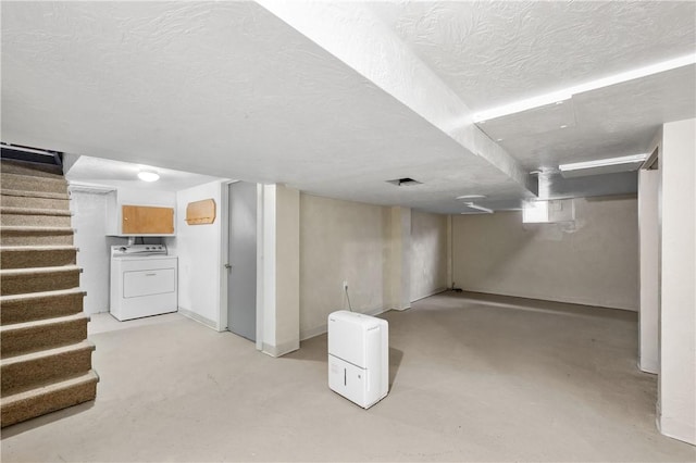 finished basement featuring a textured ceiling, stairs, and washer / clothes dryer