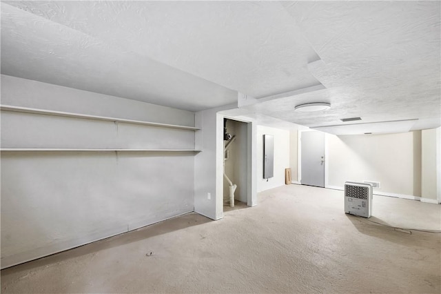 finished basement featuring stairs, carpet flooring, a textured ceiling, and visible vents