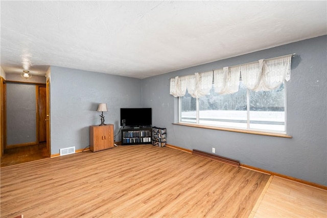 living room with baseboards, wood finished floors, and visible vents