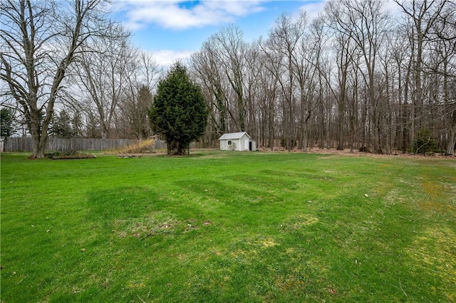 view of yard featuring fence, an outbuilding, and a storage shed
