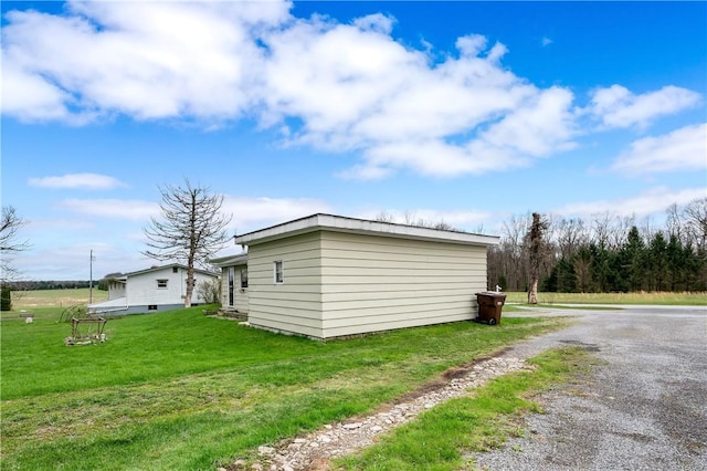 view of property exterior featuring a lawn and driveway