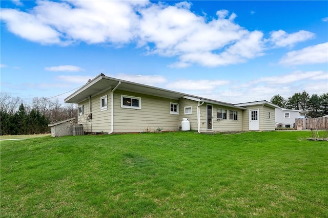 rear view of house with a lawn and central AC