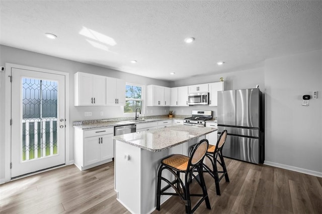 167 Alta Vista Dr, Imperial, PA 15126 - kitchen featuring stainless steel appliances, a breakfast bar, a sink, a kitchen island, and dark wood-style flooring