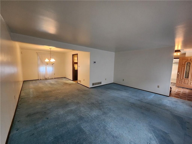 spare room with visible vents, baseboards, a notable chandelier, and carpet floors