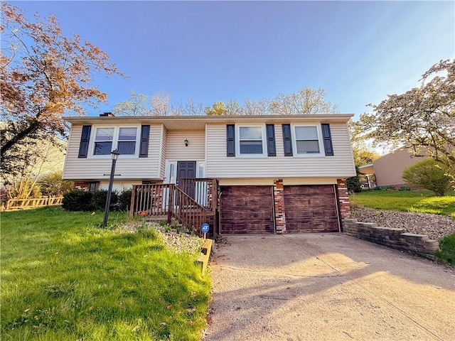 split foyer home featuring a front lawn, concrete driveway, brick siding, and an attached garage