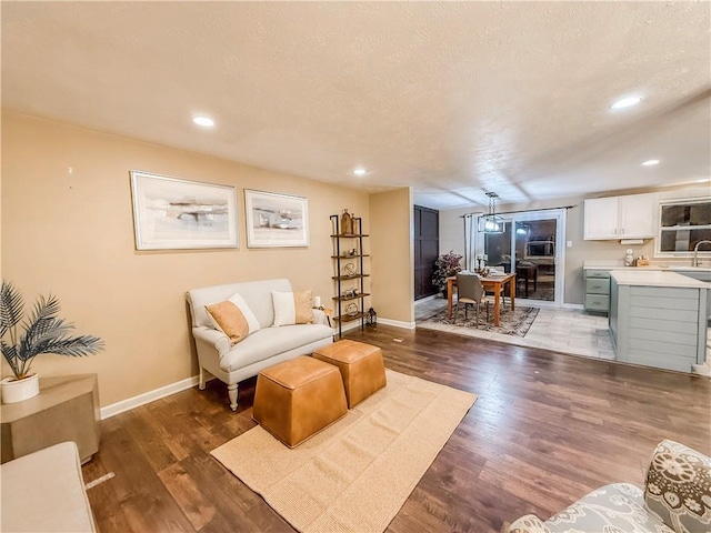 living area featuring baseboards, recessed lighting, and wood finished floors