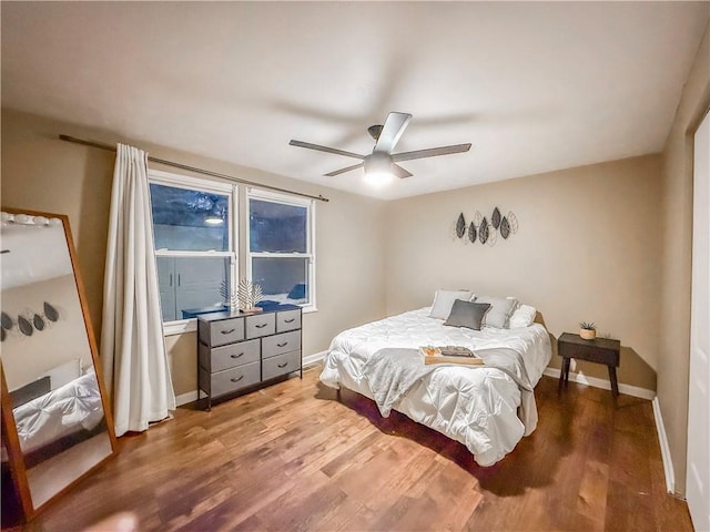 bedroom with wood finished floors, a ceiling fan, and baseboards