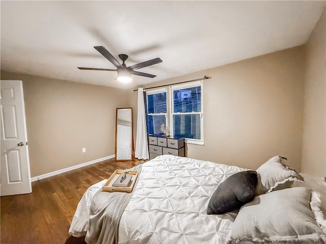 bedroom featuring wood finished floors, a ceiling fan, and baseboards