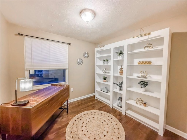interior space with dark wood-type flooring, baseboards, and a textured ceiling