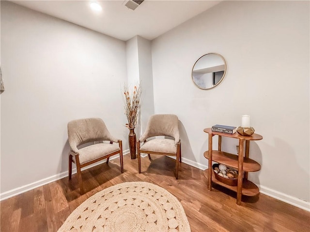 sitting room featuring wood finished floors, visible vents, and baseboards