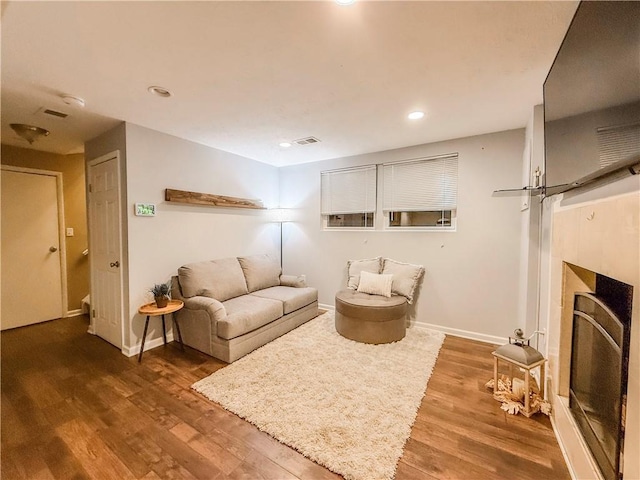 living area featuring recessed lighting, wood finished floors, a fireplace, baseboards, and visible vents