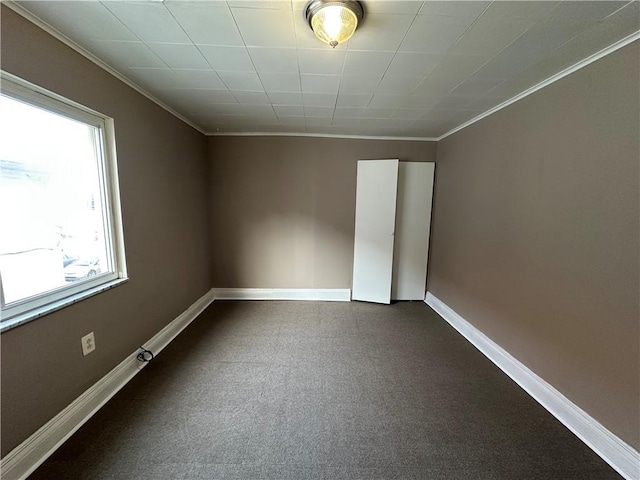 spare room with crown molding and baseboards