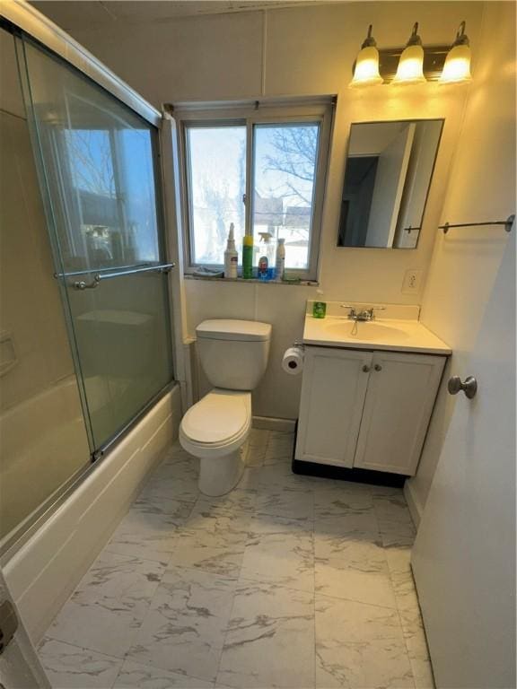 bathroom featuring combined bath / shower with glass door, vanity, toilet, and marble finish floor