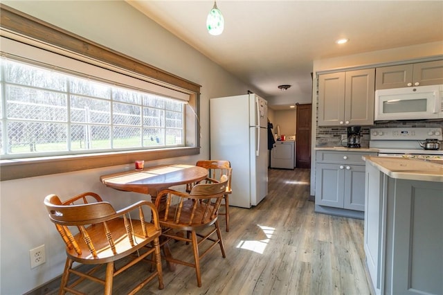 2939 Perry Hwy, Perry Twp Mer, PA 16130 - kitchen with light wood-style floors, gray cabinets, washer / dryer, backsplash, and white appliances