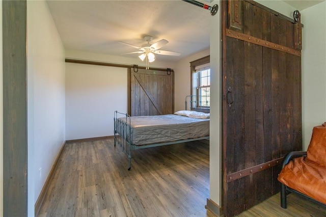 2939 Perry Hwy, Perry Twp Mer, PA 16130 - bedroom with baseboards, a barn door, light wood-type flooring, and ceiling fan