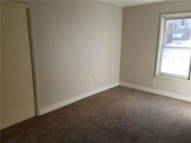 carpeted spare room with plenty of natural light and baseboards