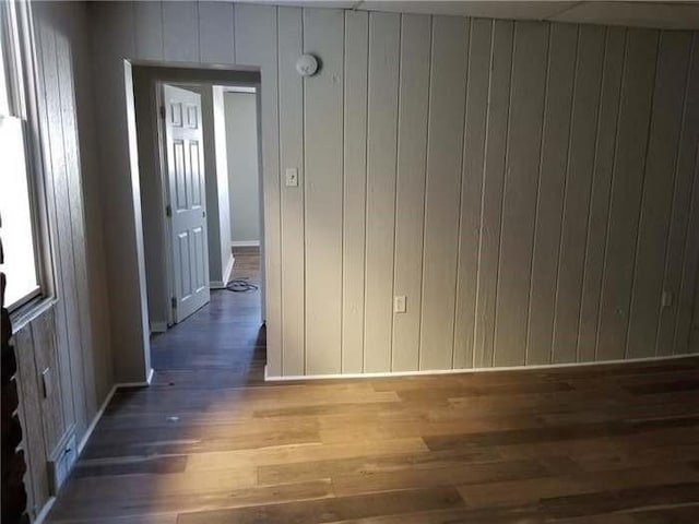interior space featuring wooden walls, wood finished floors, and baseboards
