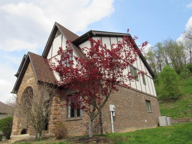 view of home's exterior with board and batten siding, brick siding, and stone siding