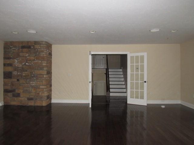 unfurnished room featuring baseboards, recessed lighting, wood finished floors, and french doors