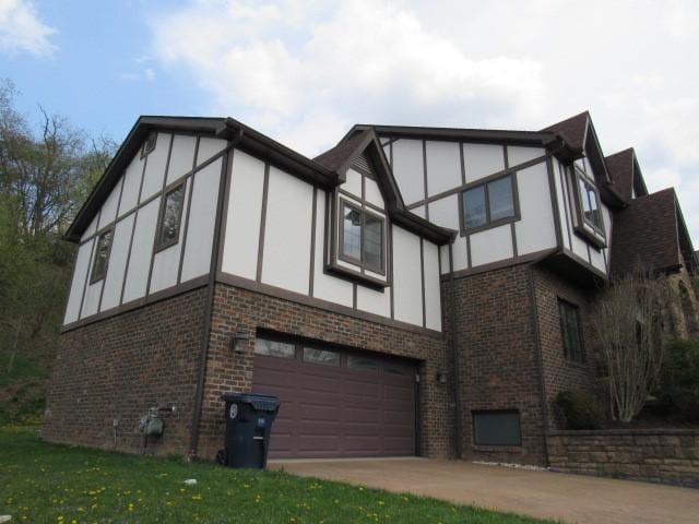 view of side of home with brick siding, stucco siding, concrete driveway, and an attached garage