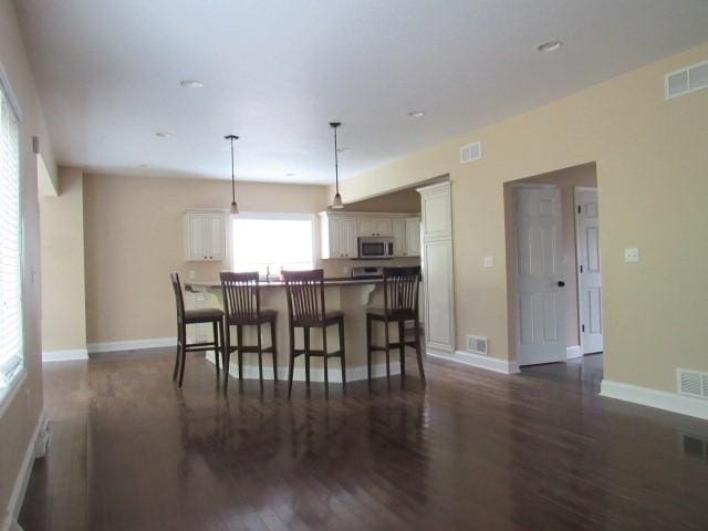 dining space featuring dark wood-style flooring and visible vents