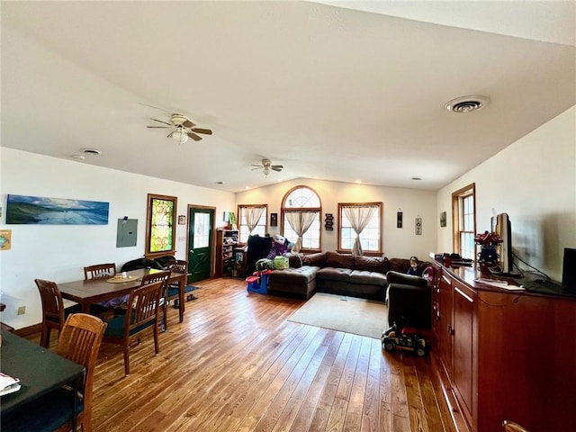 living area with visible vents, hardwood / wood-style flooring, a ceiling fan, and lofted ceiling