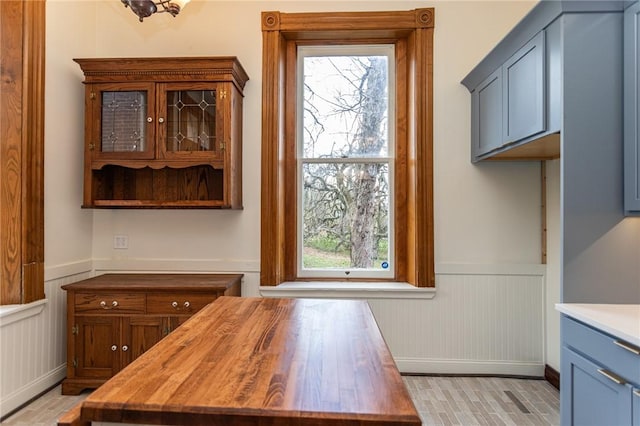 interior space featuring plenty of natural light, a wainscoted wall, and baseboards