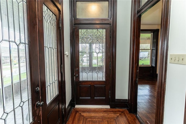 doorway with dark wood-style floors and baseboards