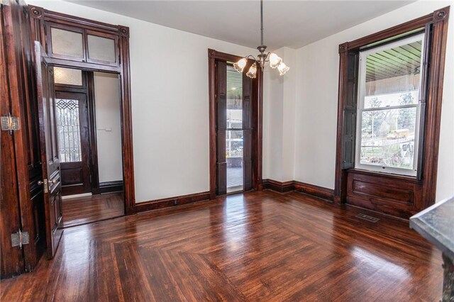 unfurnished dining area with an inviting chandelier, a wealth of natural light, and baseboards