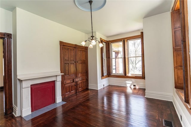 unfurnished living room with baseboards, visible vents, a fireplace with flush hearth, and dark wood finished floors