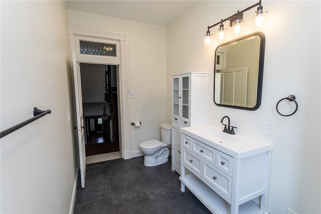 bathroom featuring baseboards, toilet, tile patterned flooring, and vanity