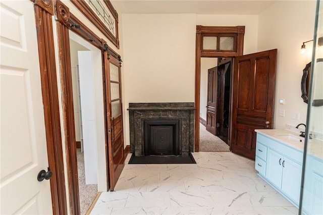 bathroom with marble finish floor, vanity, and a fireplace