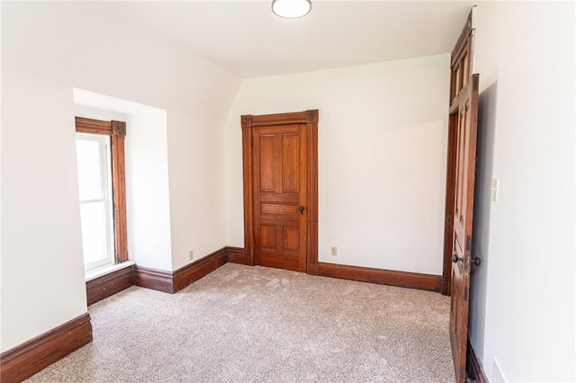 carpeted empty room featuring baseboards