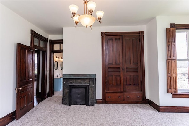 carpeted living area featuring an inviting chandelier and baseboards