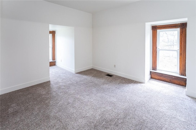 unfurnished room featuring baseboards, visible vents, and carpet flooring