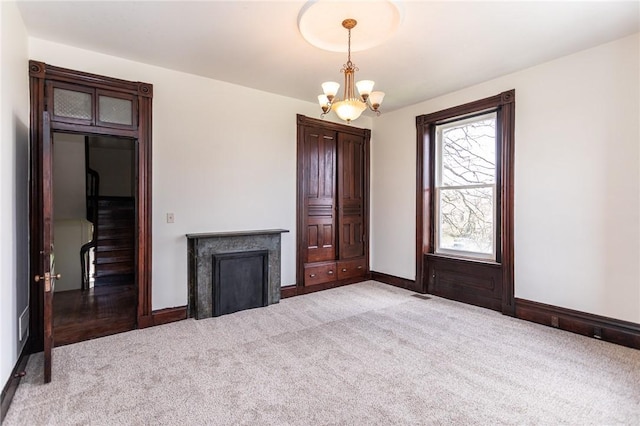 living area with a chandelier, light carpet, and baseboards
