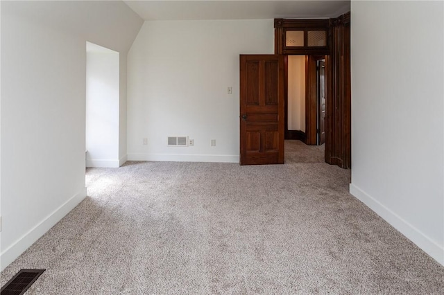 carpeted spare room featuring visible vents and baseboards