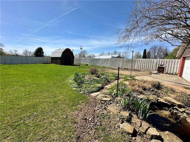 view of yard featuring an outbuilding, a shed, and a fenced backyard